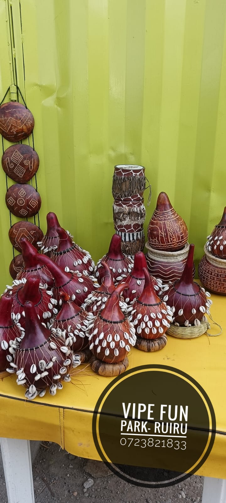 Traditional decorated calabash gourds, drums and carved wall pieces displayed together