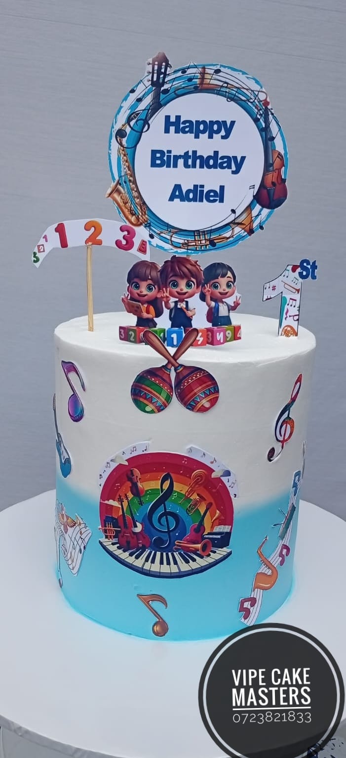 White and blue first birthday cake with musical instruments, notes, rainbow and Happy Birthday Adiel topper