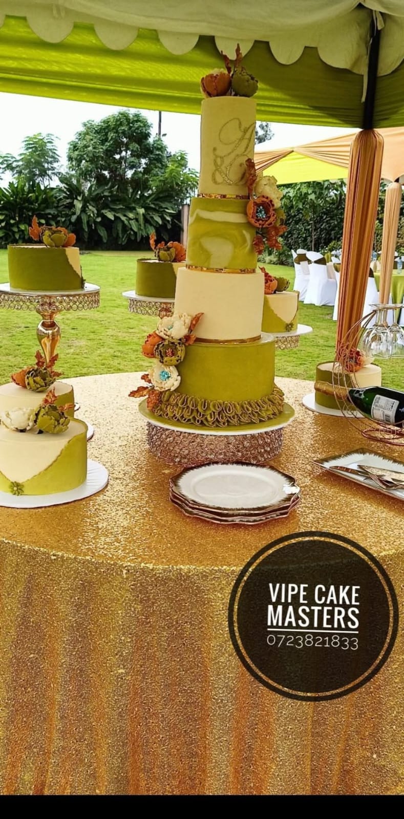 Olive green and ivory wedding cake collection with handcrafted autumn flowers on a gold table