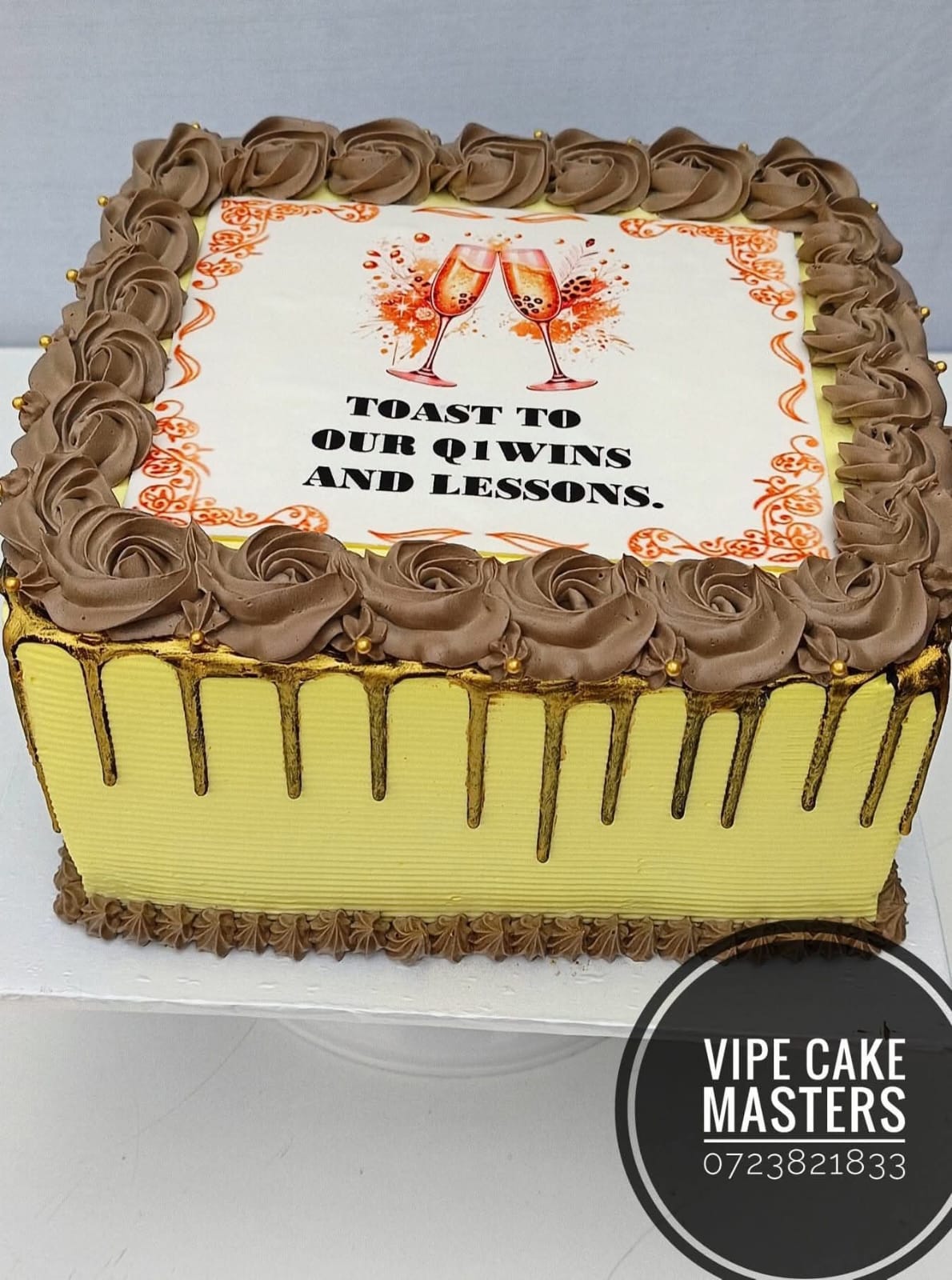Rectangular corporate cake with champagne glasses, chocolate rose border and Toast to our Q1 wins and lessons message