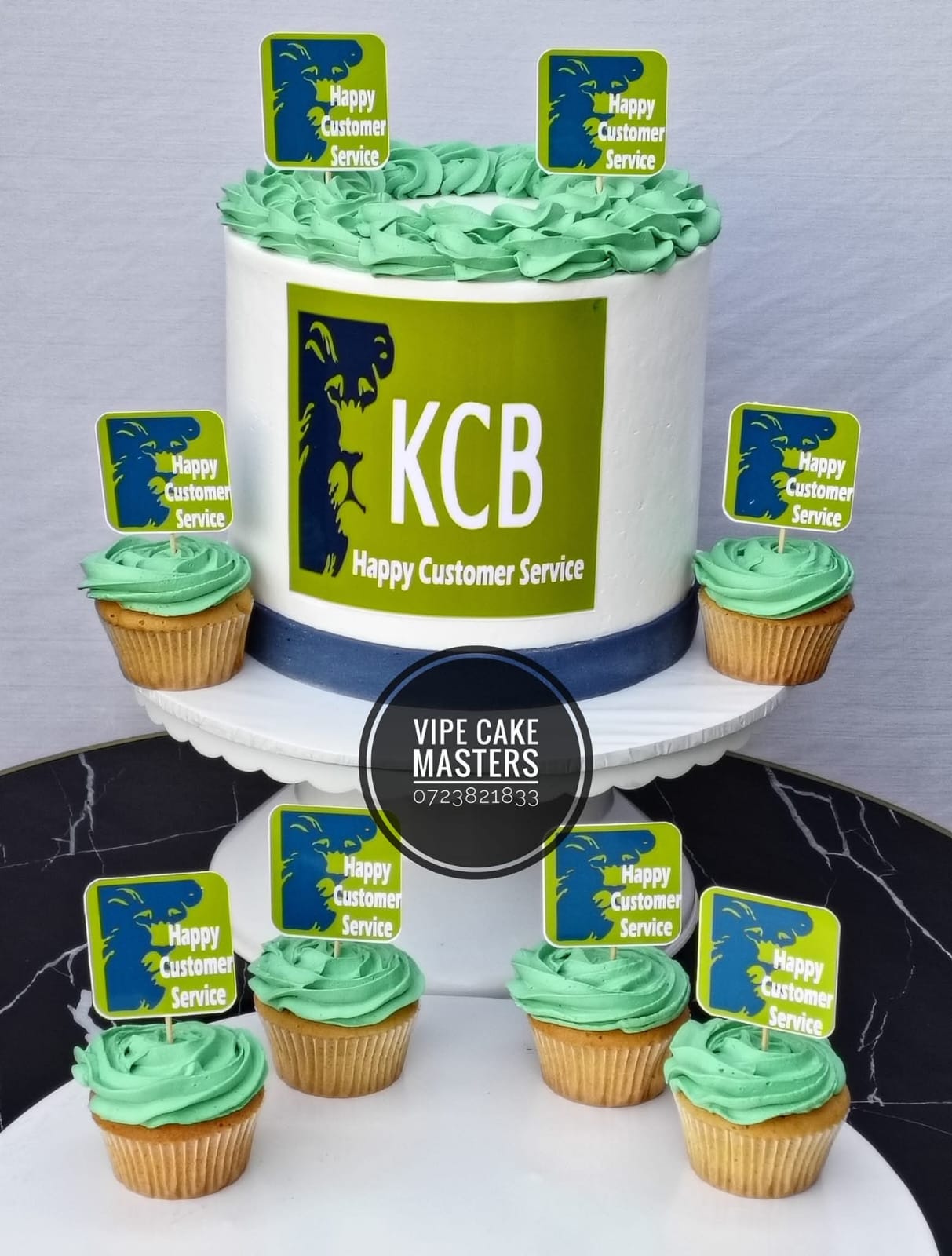 Corporate KCB cake with Happy Customer Service logo and matching green frosted cupcakes