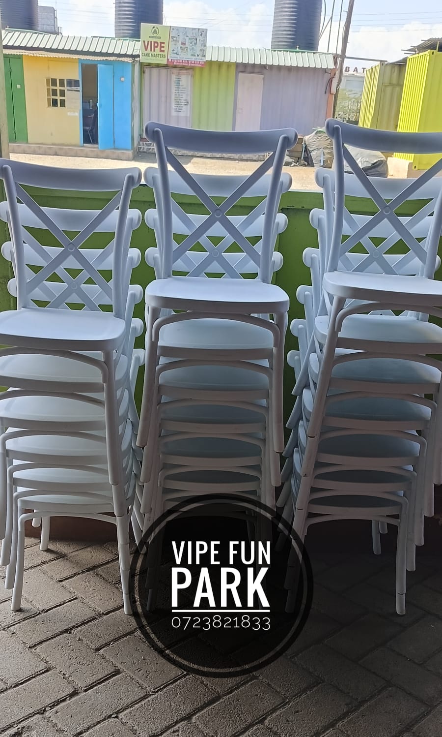 Stacks of white cross-back event chairs outside the Vipe premises