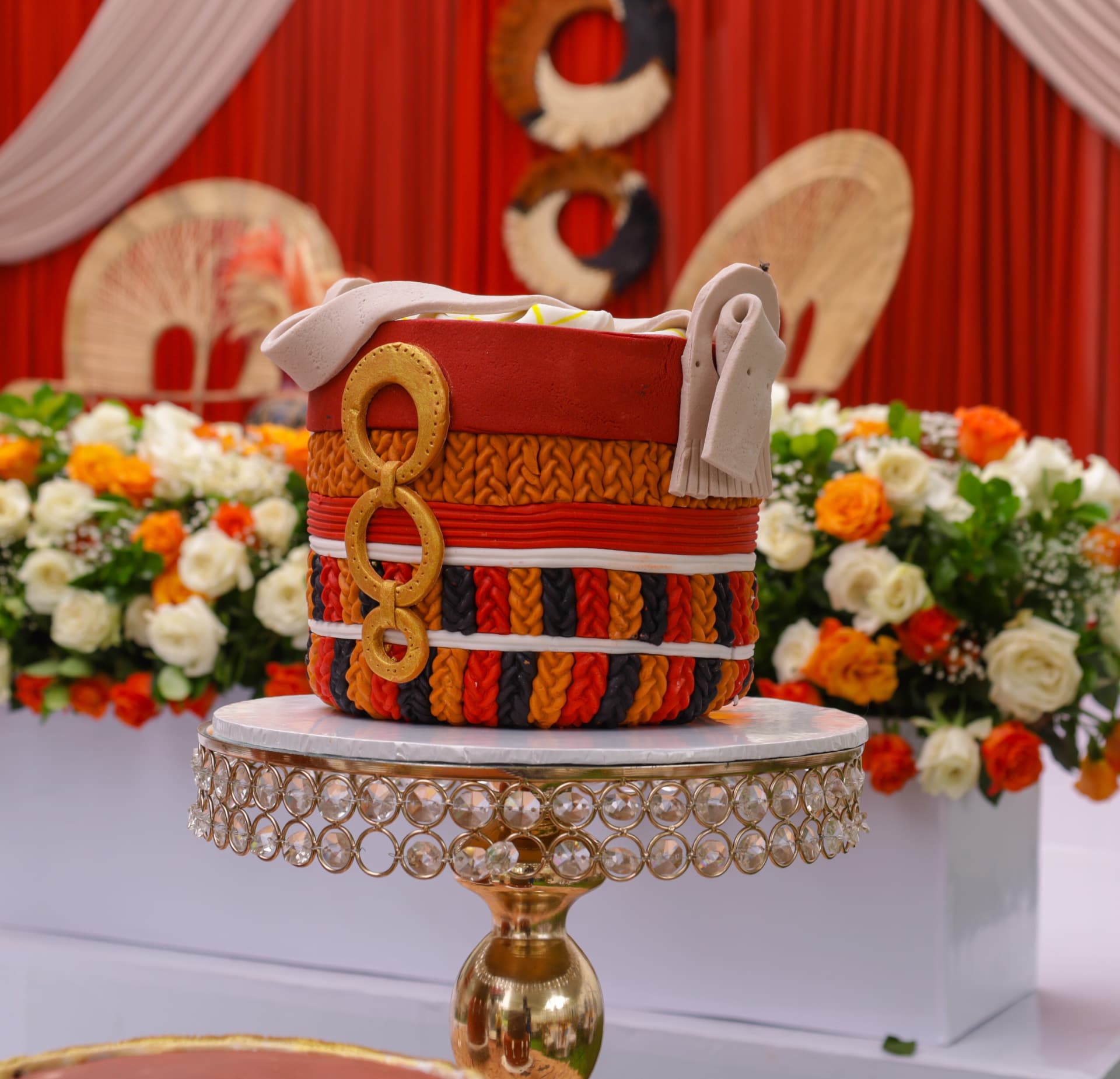 Detailed celebration cake inspired by a woven African basket in red, orange and black
